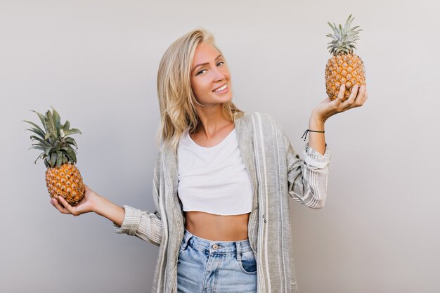 woman holding exotic fruits with sincere smile.