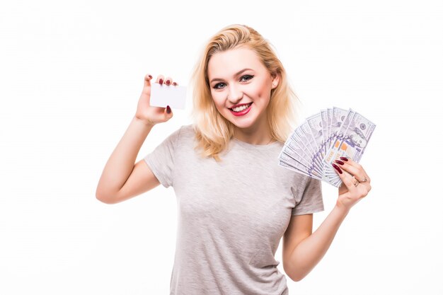 Woman holding fan of money and white credit card isolated on white wall