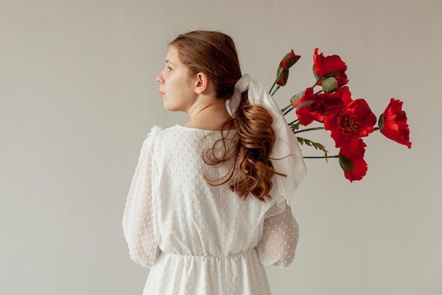 Free photo woman holding flowers back view