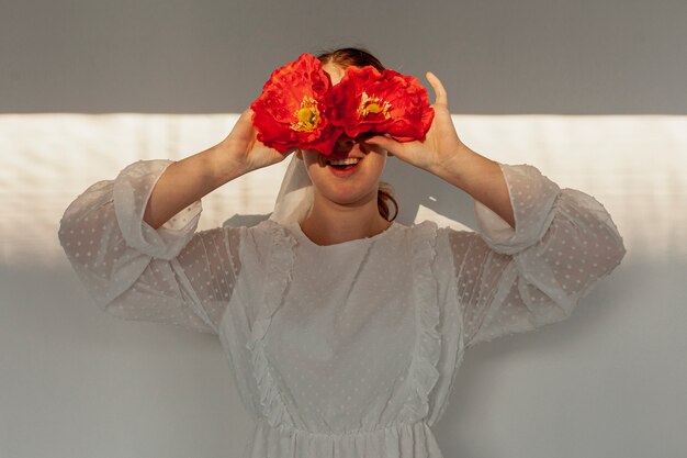 Woman holding flowers over eyes