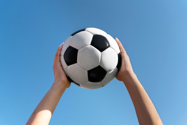 Woman holding a football up in the air