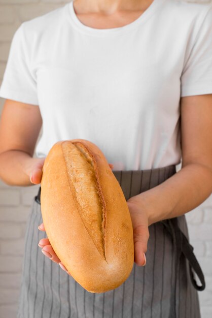 焼きたてのパンを保持している女性