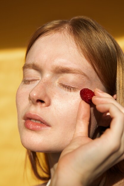 Woman holding fresh raspberry close up