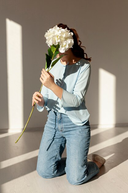 新鮮な春の花を保持している女性