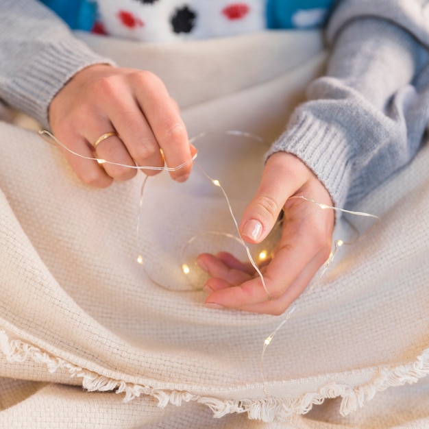 Free photo woman holding garland in hands