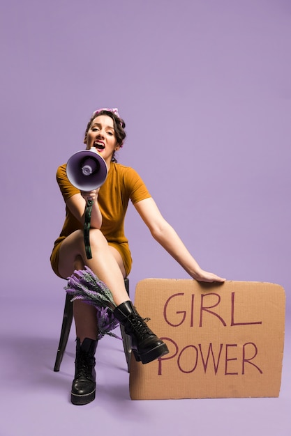 Woman holding "girl power" cardboard gender equality and shouting