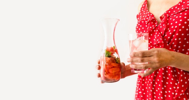 Foto gratuita la donna che giudica di vetro con acqua e l'anguria copiano lo spazio