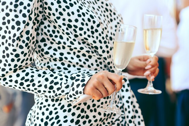 Woman holding goblets with champagne