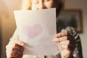 Free photo woman holding greeting card with i love you mum inscription