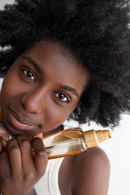 Foto gratuita vista frontale dei prodotti per capelli della holding della donna