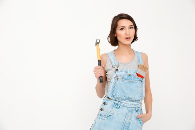 woman holding hammer, renovating house, building