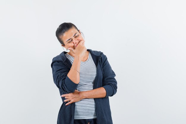 Woman holding hand on chin in t-shirt