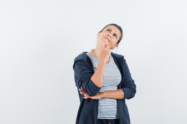 Woman holding hand on chin in t-shirt