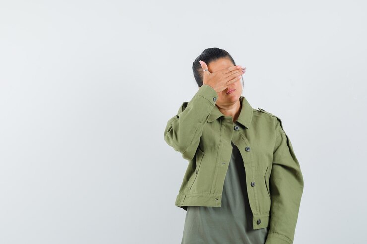 Free Photo woman holding hand on eyes in jacket, t-shirt and looking calm.