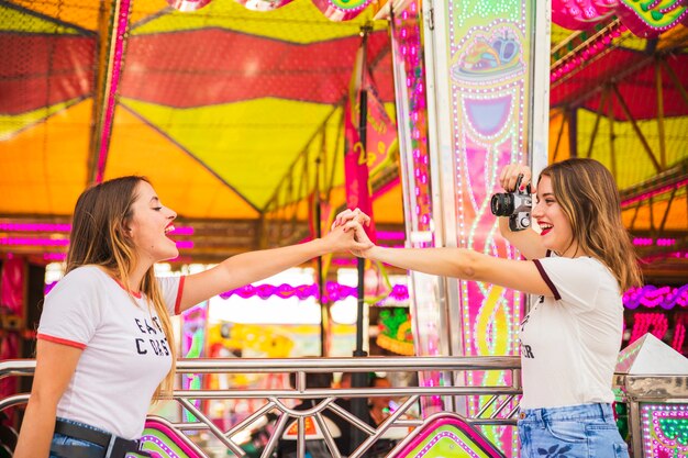 Woman holding hand while taking selfie of her friend