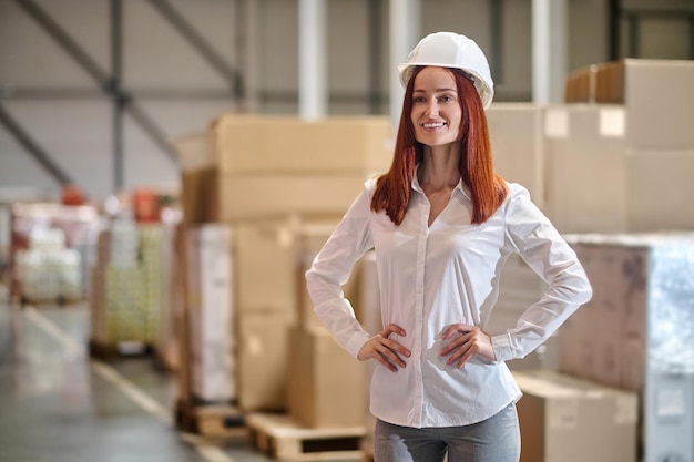 Woman holding hands on belt standing near boxes