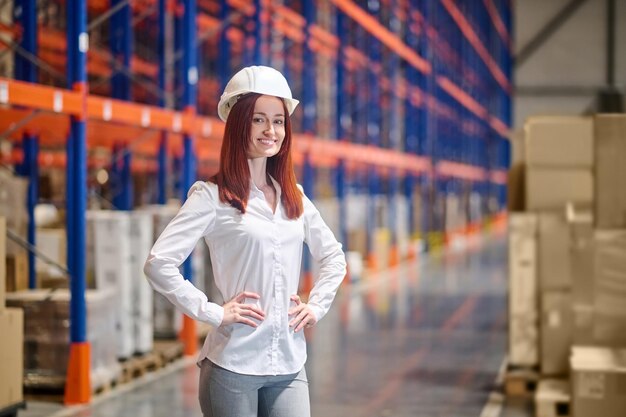 Woman holding hands on belt standing in warehouse