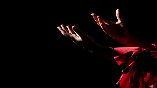 Woman holding hands on black background