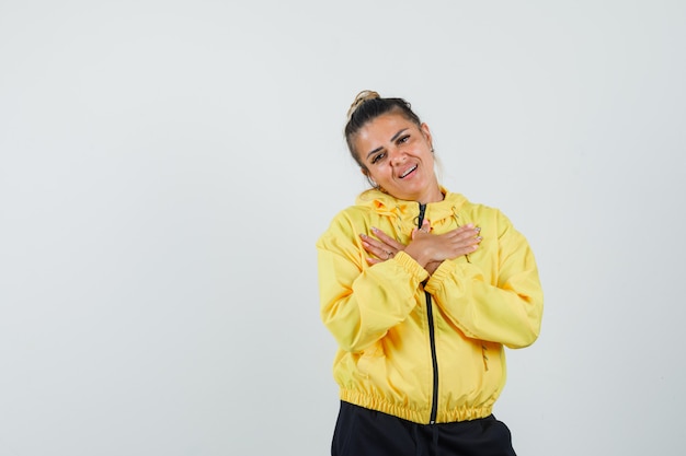 Woman holding hands on chest in sport suit and looking grateful. front view.