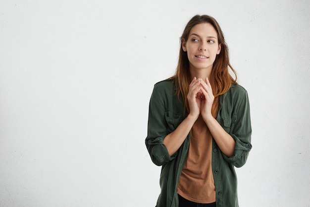 woman holding hands together looking aside trying to imagine her next project finding solution isolated