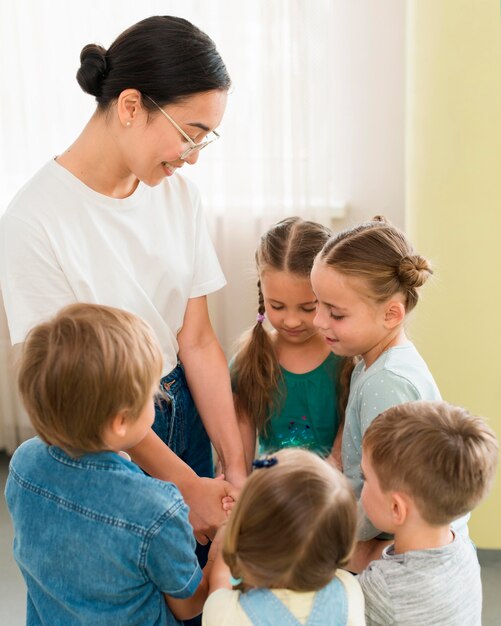 Woman holding hands with her students