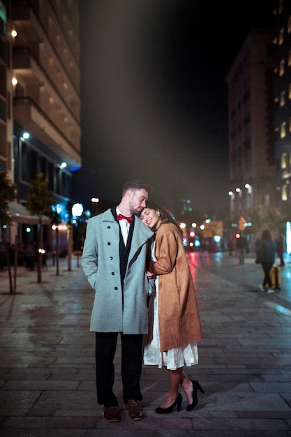 Woman holding head on man shoulder in street 