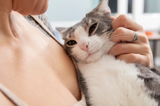 Woman holding her adorable kitty at home