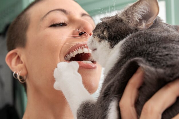 Woman holding her adorable kitty at home