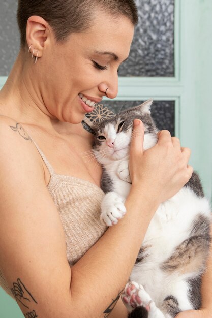 Woman holding her adorable kitty at home