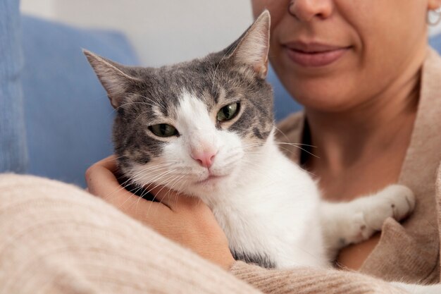 Woman holding her adorable kitty at home