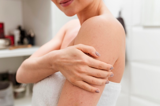 Woman holding her arm in the bathroom