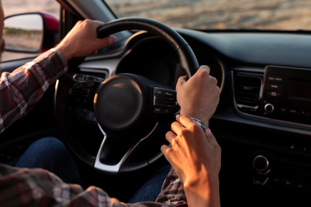 Free photo woman holding her boyfriends hand while driving