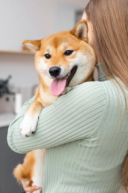 여자가 그녀의 팔에 그녀의 개를 들고