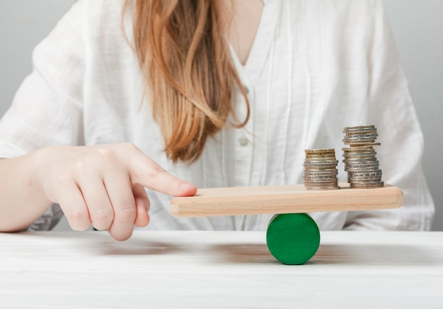 Woman holding her finger in balance with the coins