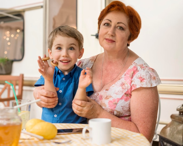 Woman holding her grandson outside next to a caravan