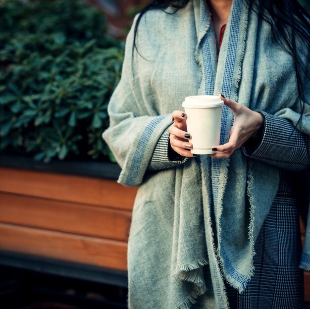 Woman holding in her hands a cup of coffee 1