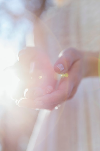 Женщина держит ее руки в солнечном свете