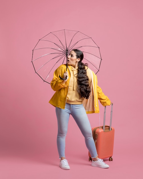 Woman holding her luggage while looking away