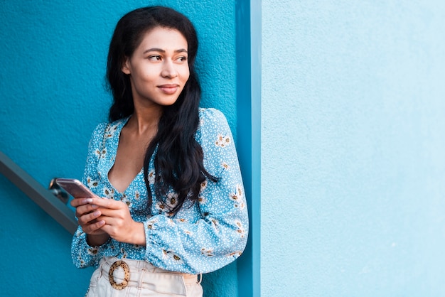 Woman holding her phone and looking away