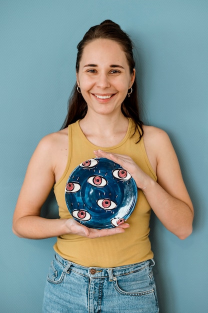 Free photo woman holding her pottery creations