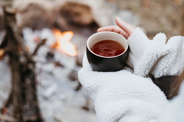 屋外で熱いお茶を持っている女性