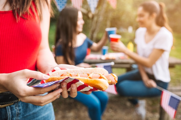 ピクニックにホットドッグを持つ女性