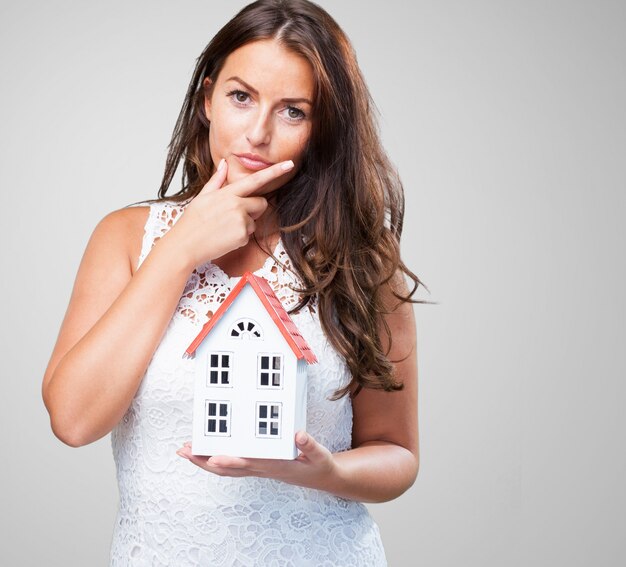 woman holding a house and thinking about something