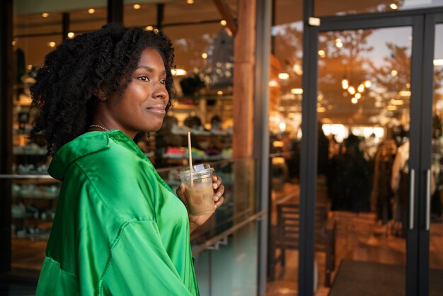 Woman holding iced coffee side view