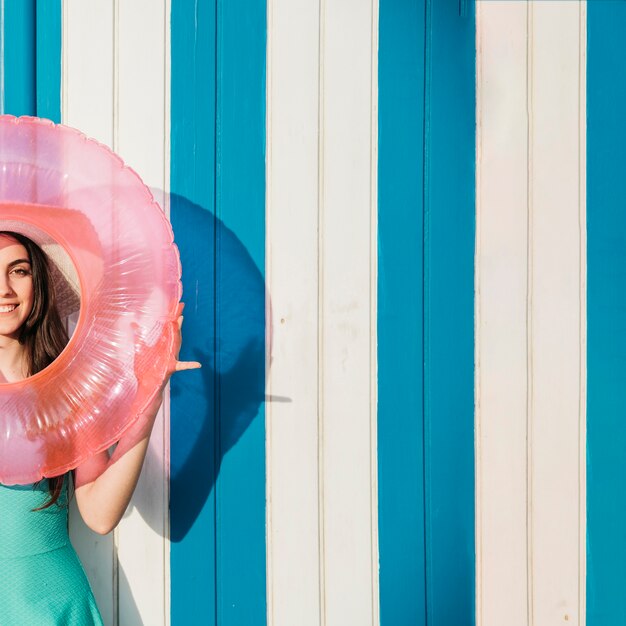 Woman holding inflatable ring around face with copyspace