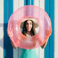 Free photo woman holding inflatable ring around face