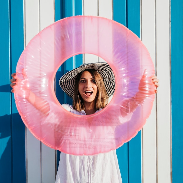 Woman holding inflatable ring around face