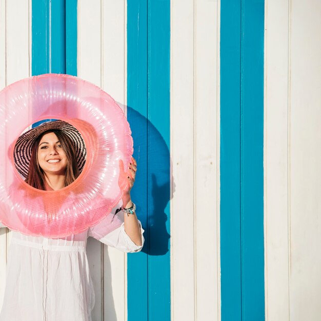 Woman holding inflatable ring around face