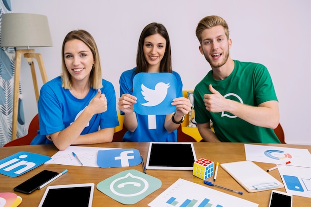 Woman holding instagram icon with his friends showing thumbup sign