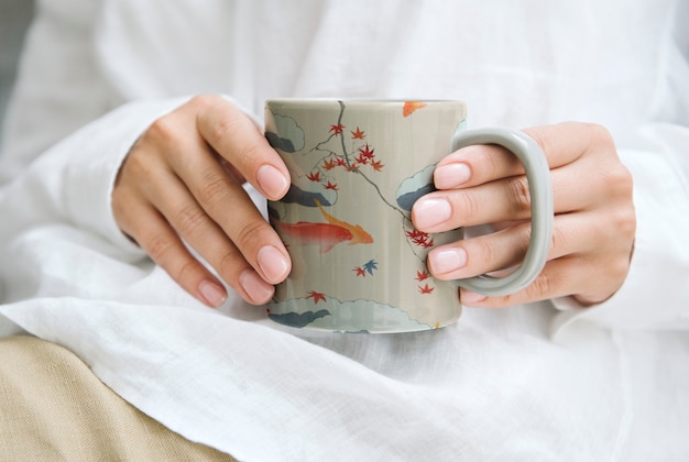 Foto gratuita donna che tiene una tazza da caffè con motivo giapponese, remix di opere d'arte di watanabe seitei